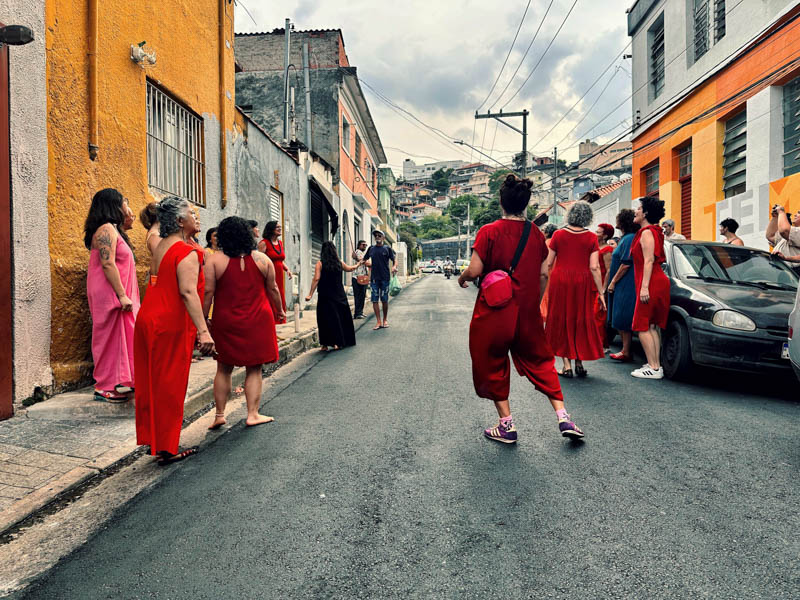 Coral de mulheres cantando nas ruas da vila anglo